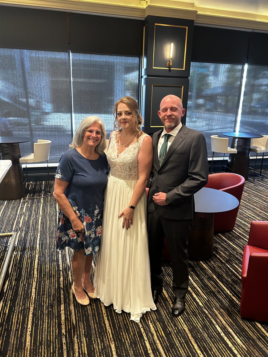 Beth with the bride and groom on their wedding day